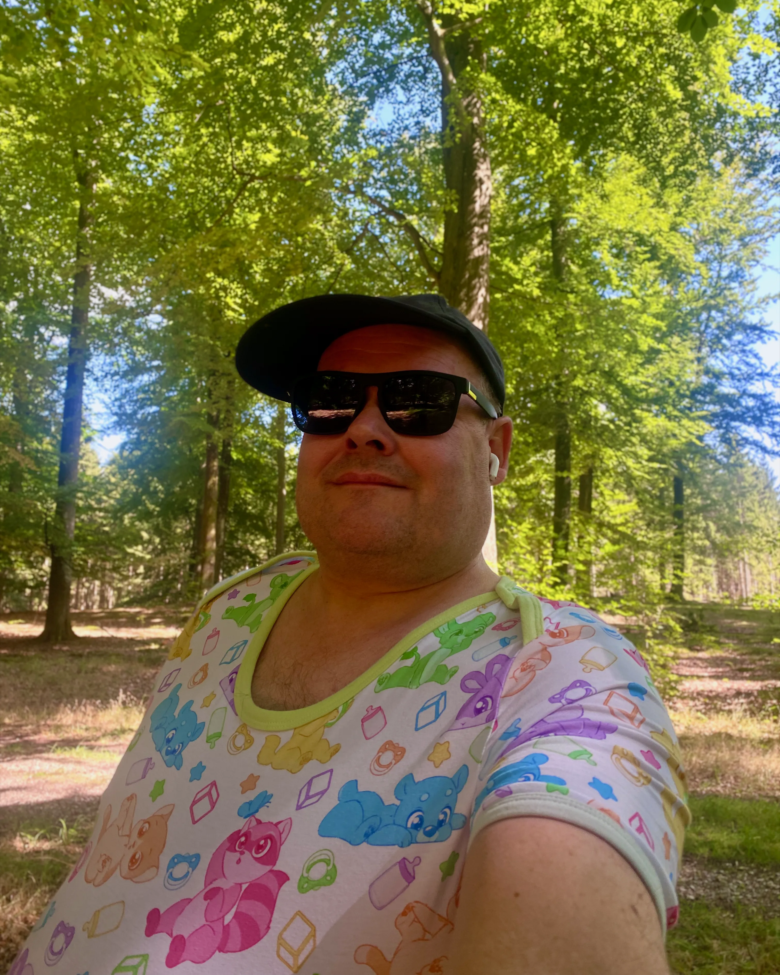 Babylai i skoven, solbriller og kasket, smil